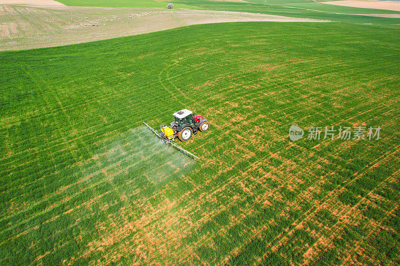 Spraying with a red tractor in Eskişehir agricultural lands, aerial shot